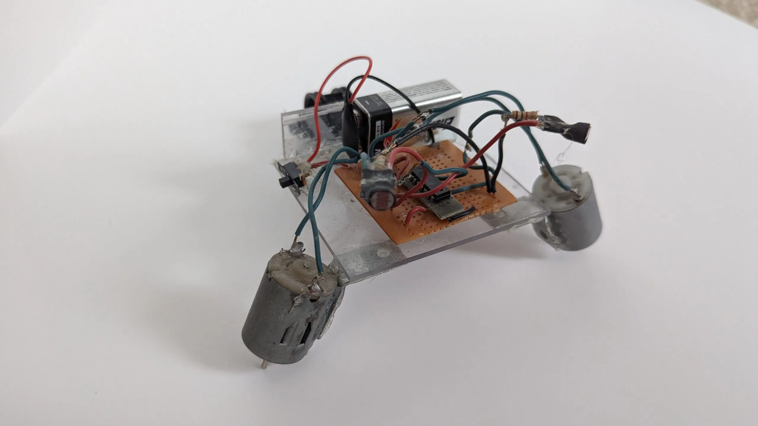 Rear three-quarter of NoBB: 9V and trim pot riding the clear chassis above the protoboard.