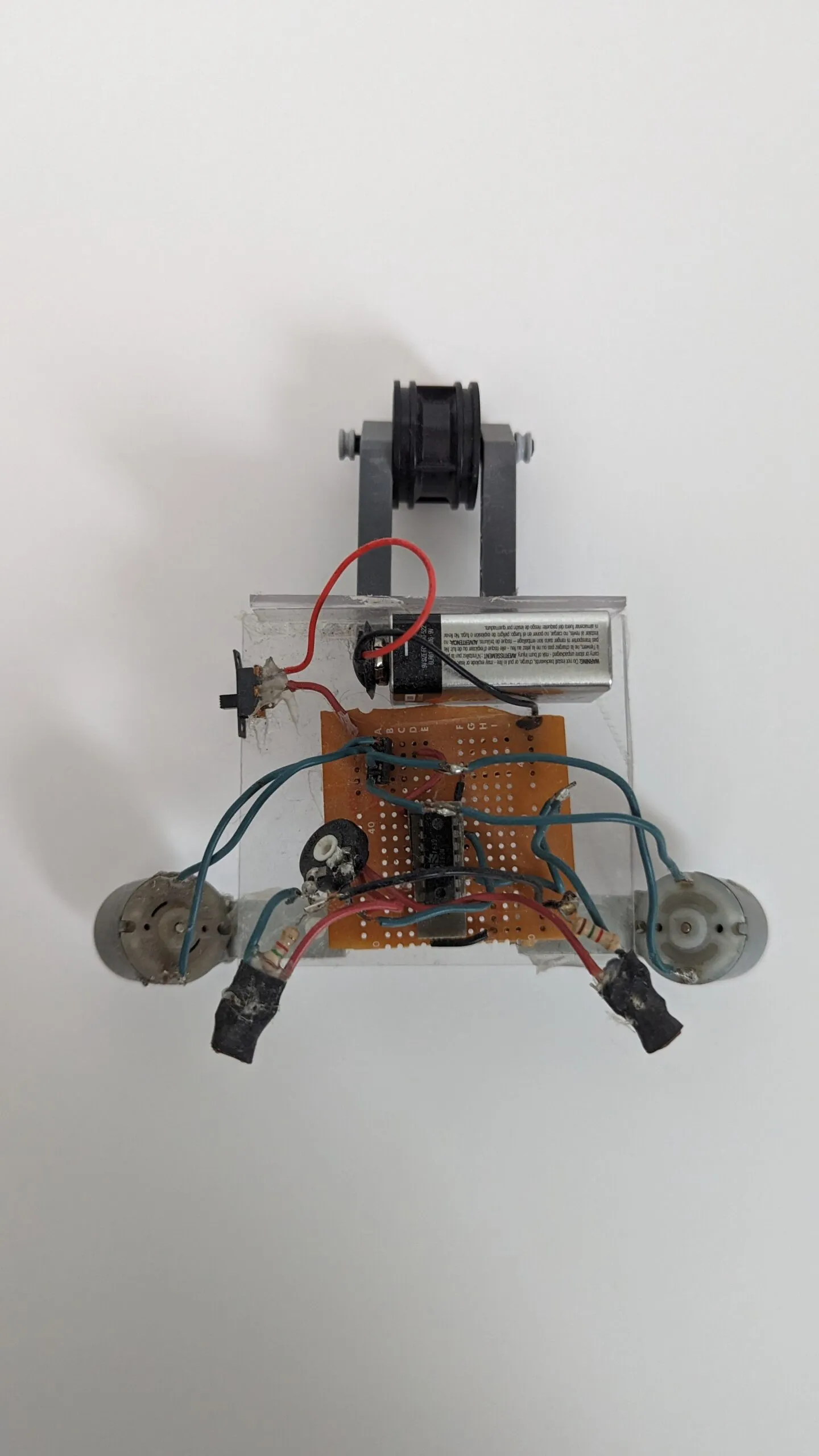 Top-down view of NoBB: LEGO caster arm out front, then the 9V, protoboard brain, and splayed motors.