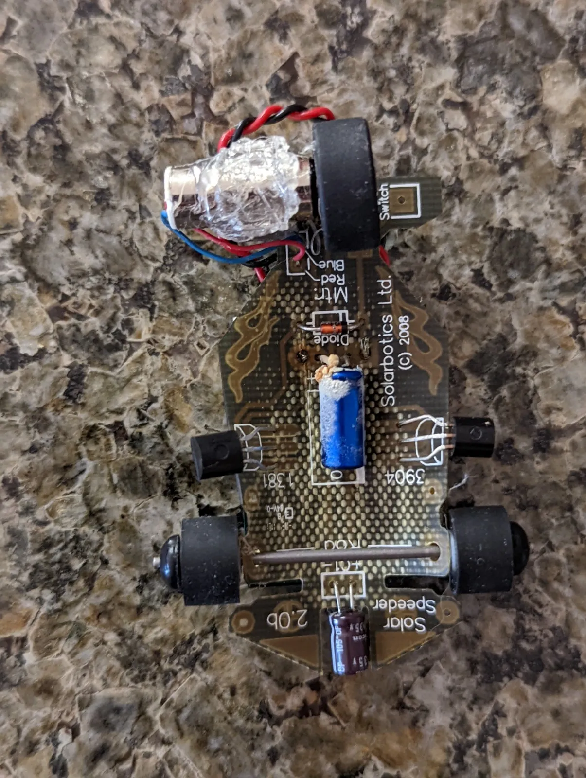 Underside of the Solar Roller's PCB with the blue storage capacitor crusted white where it leaked.