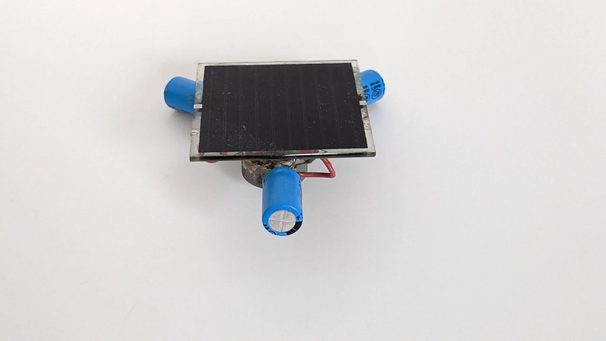 Three-quarter top view of the Symet showing the solar cell and two of its capacitor feet.