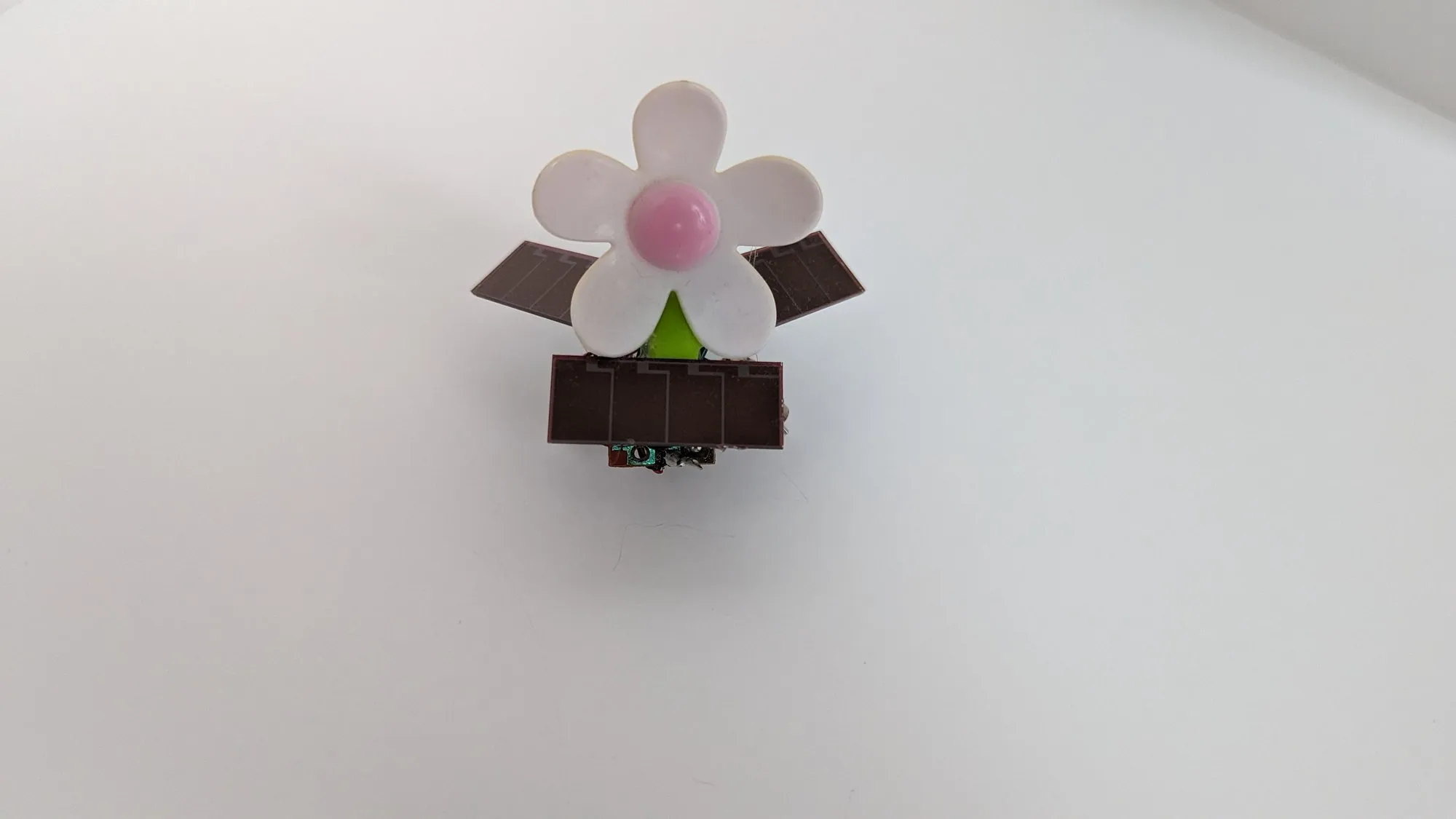 SymFlower v2 straight from above: the daisy centered over the front panel, solar wings out to both sides.