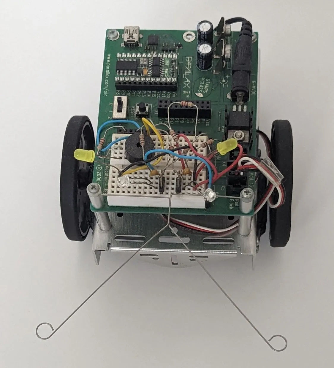 Top-down view of the BOE-Bot: the Board of Education on top, breadboard wiring, whiskers trailing forward.