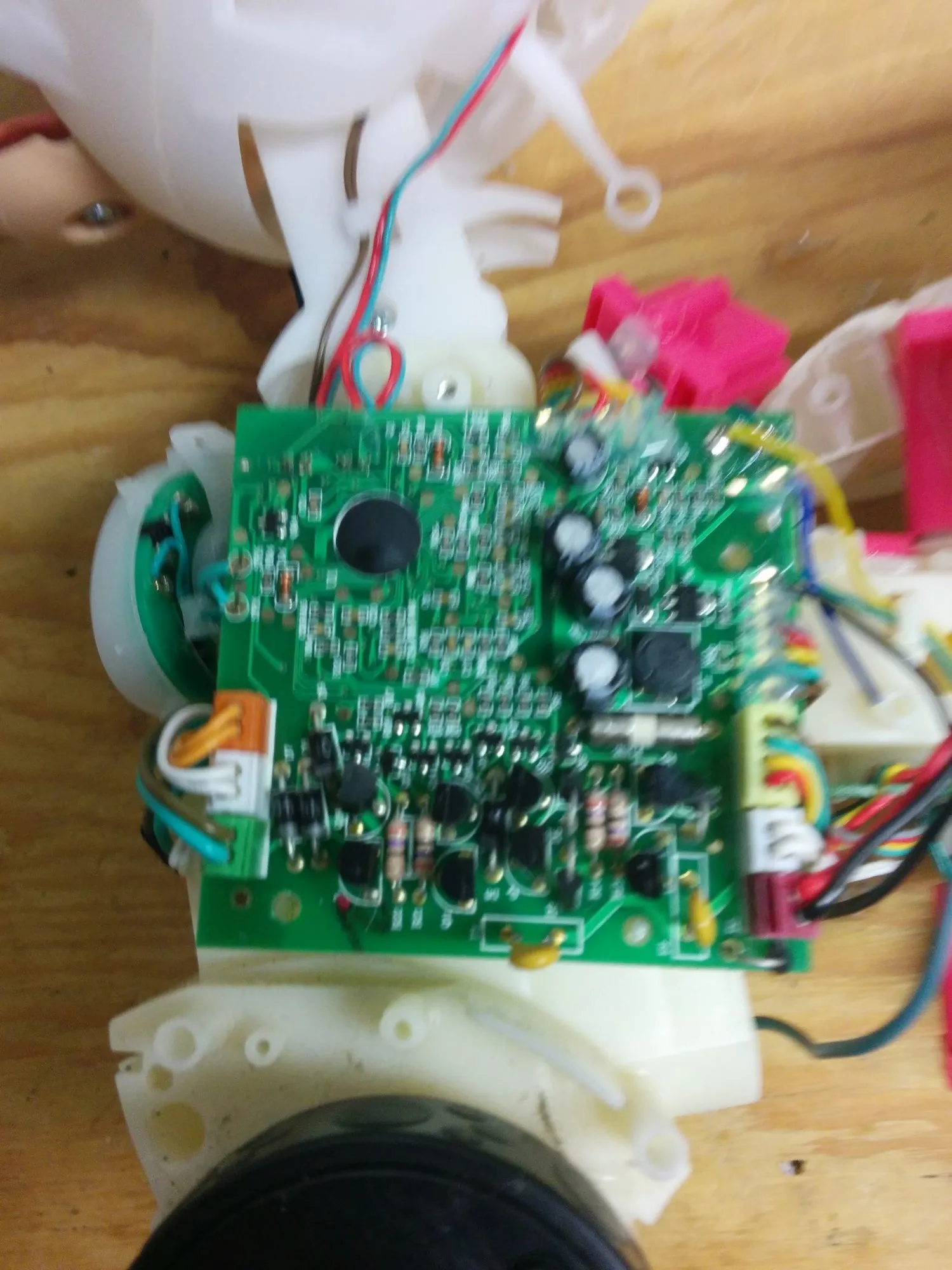 The toy's original control board exposed in the body shell, wiring harness and pink parts around it.