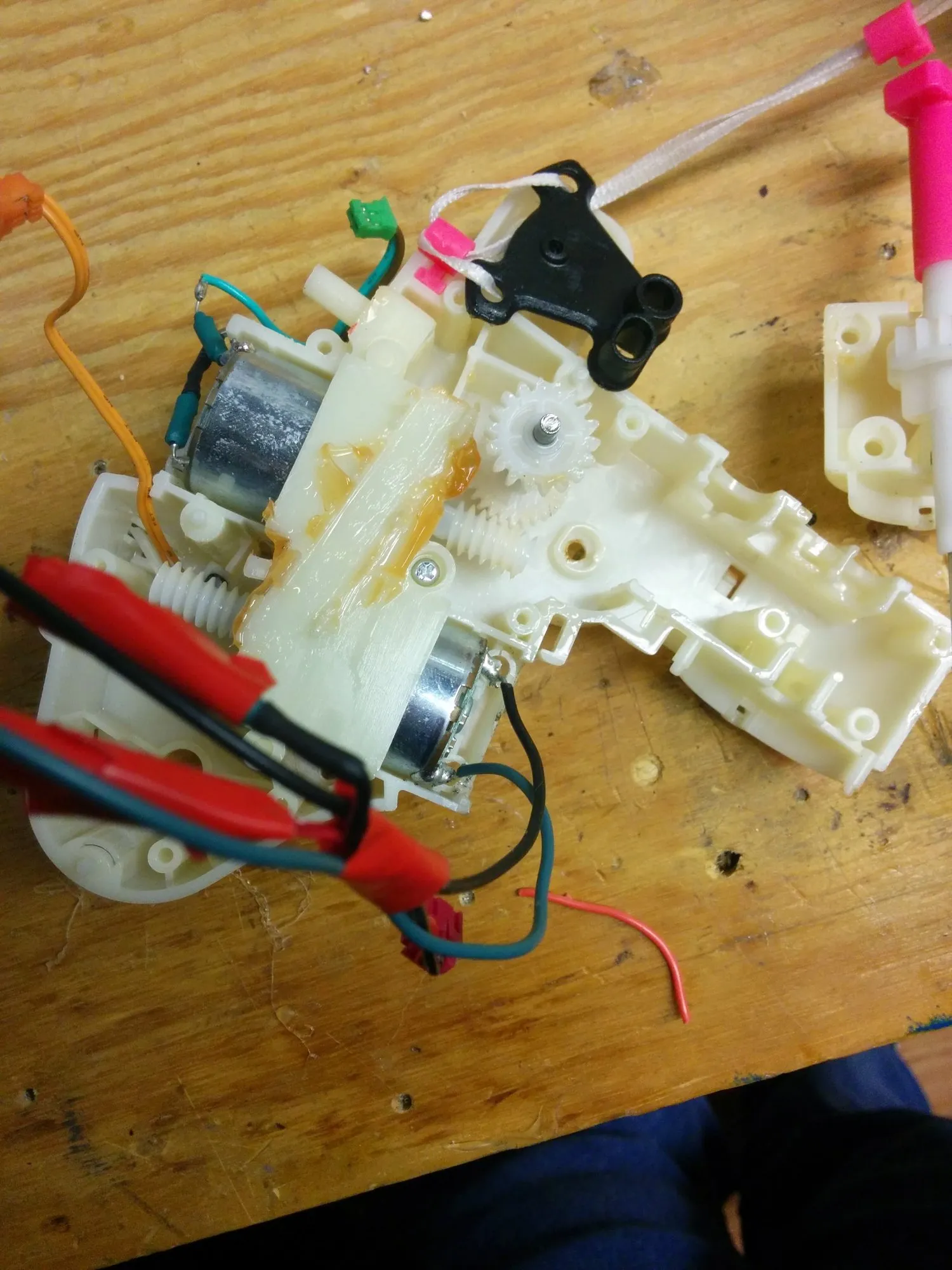 The drivetrain gearbox out of the toy with both motors in place, clip leads on one of them and the tail linkage still attached.