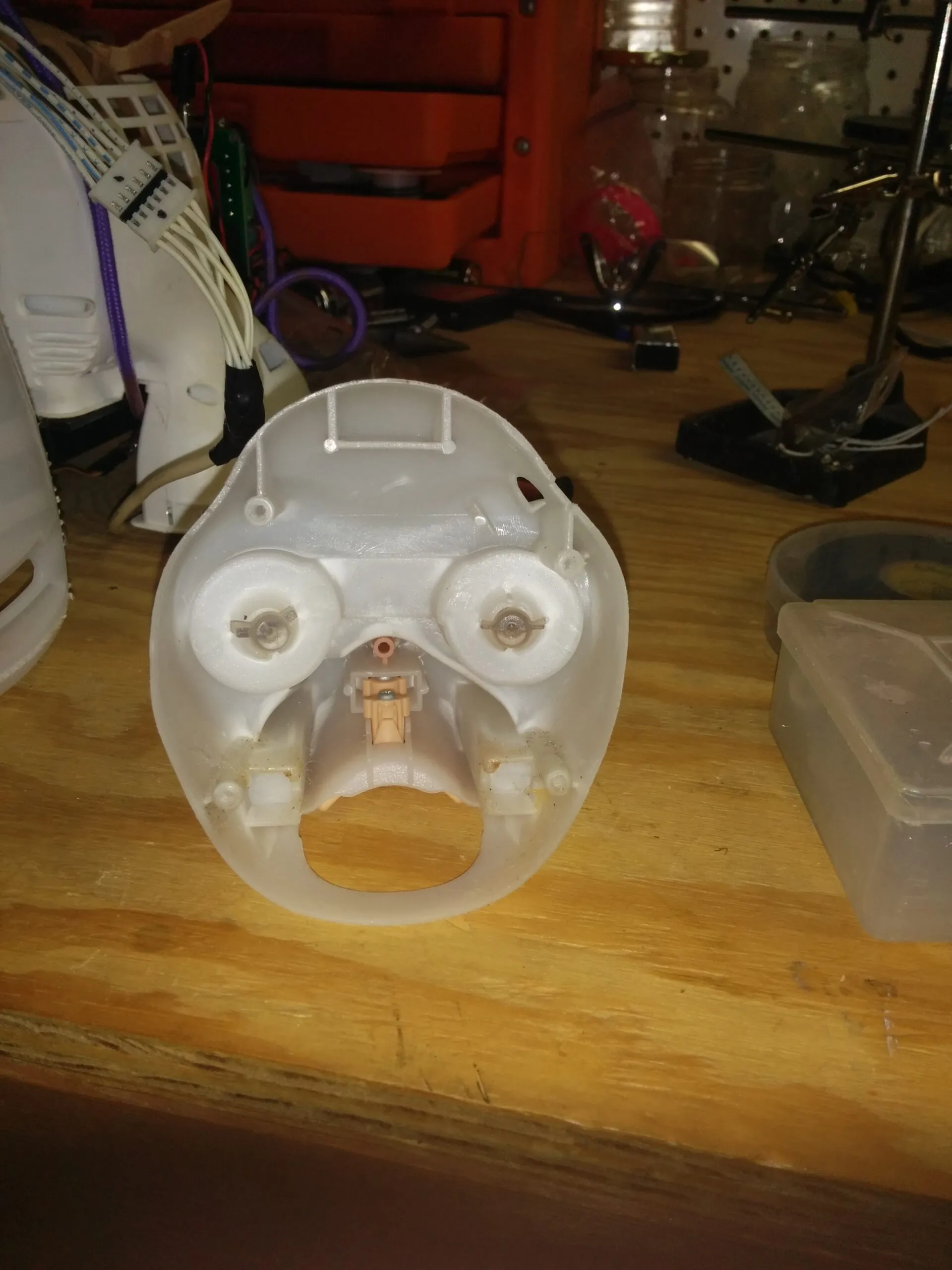 The back side of Bubbles' face shell, eye mechanisms staring back like a little skull.