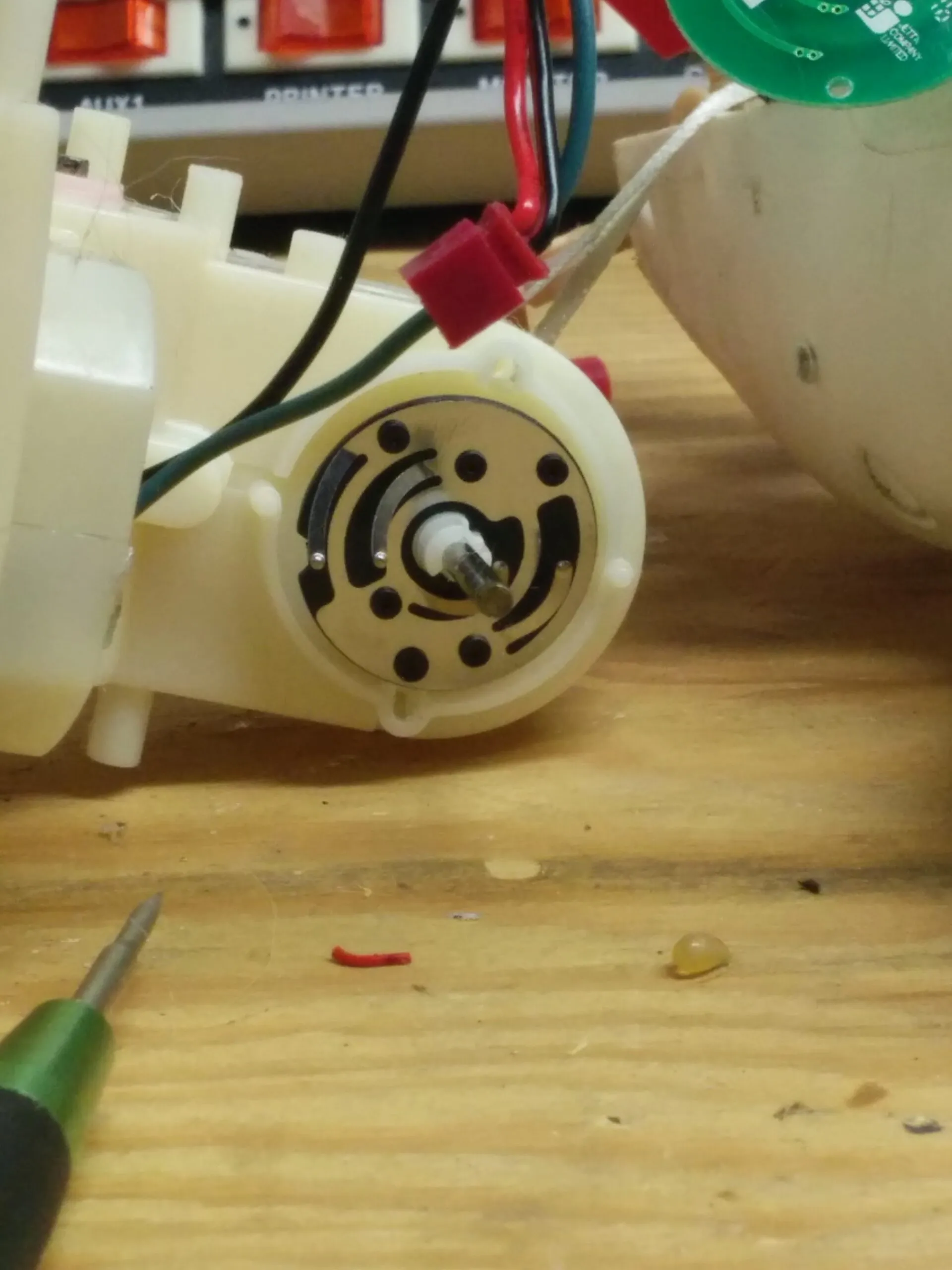 Close-up of a Bubbles gearbox output: a printed contact disc with wiper brushes the toy uses to sense position.