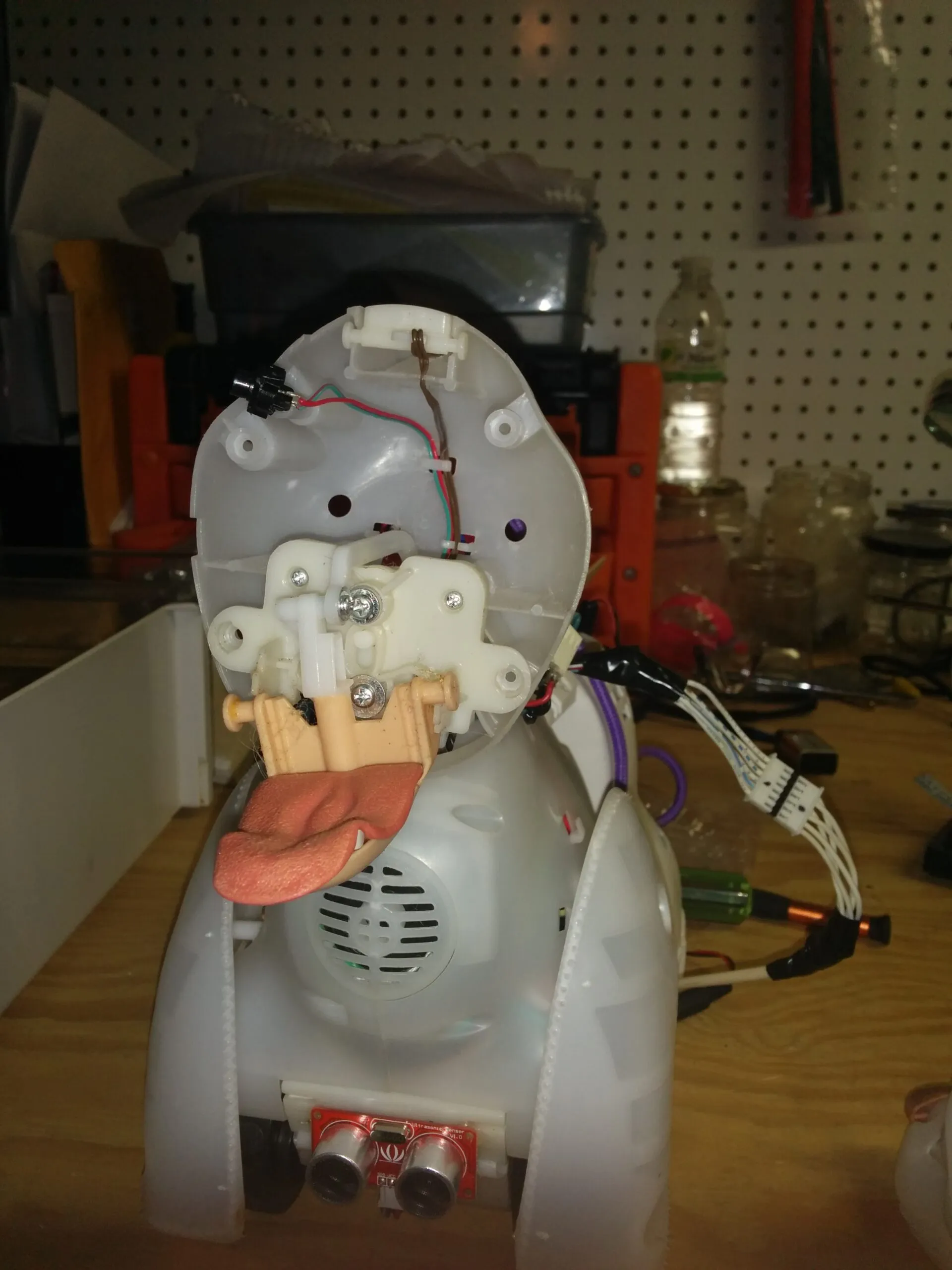 Bubbles' head shell tipped open: tongue linkage, speaker grille, and the ultrasonic sensor in the chest.