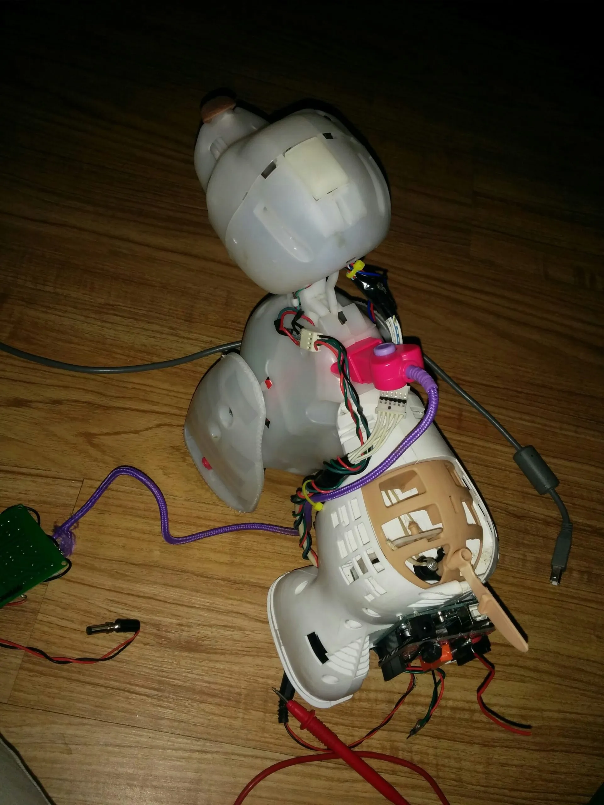 Bubbles mid-teardown on the floor, shells off and multimeter leads already out.