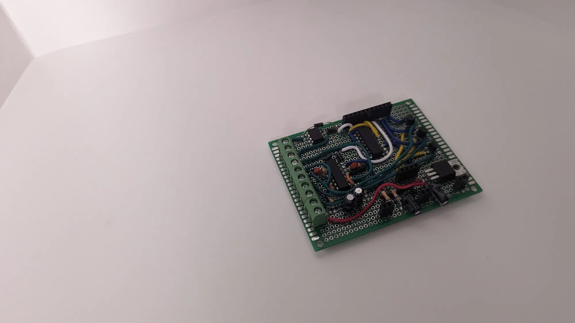 The NodeMCU daughterboard on its own, a NodeMCU seated in headers on a small perfboard with blue and yellow jumpers.