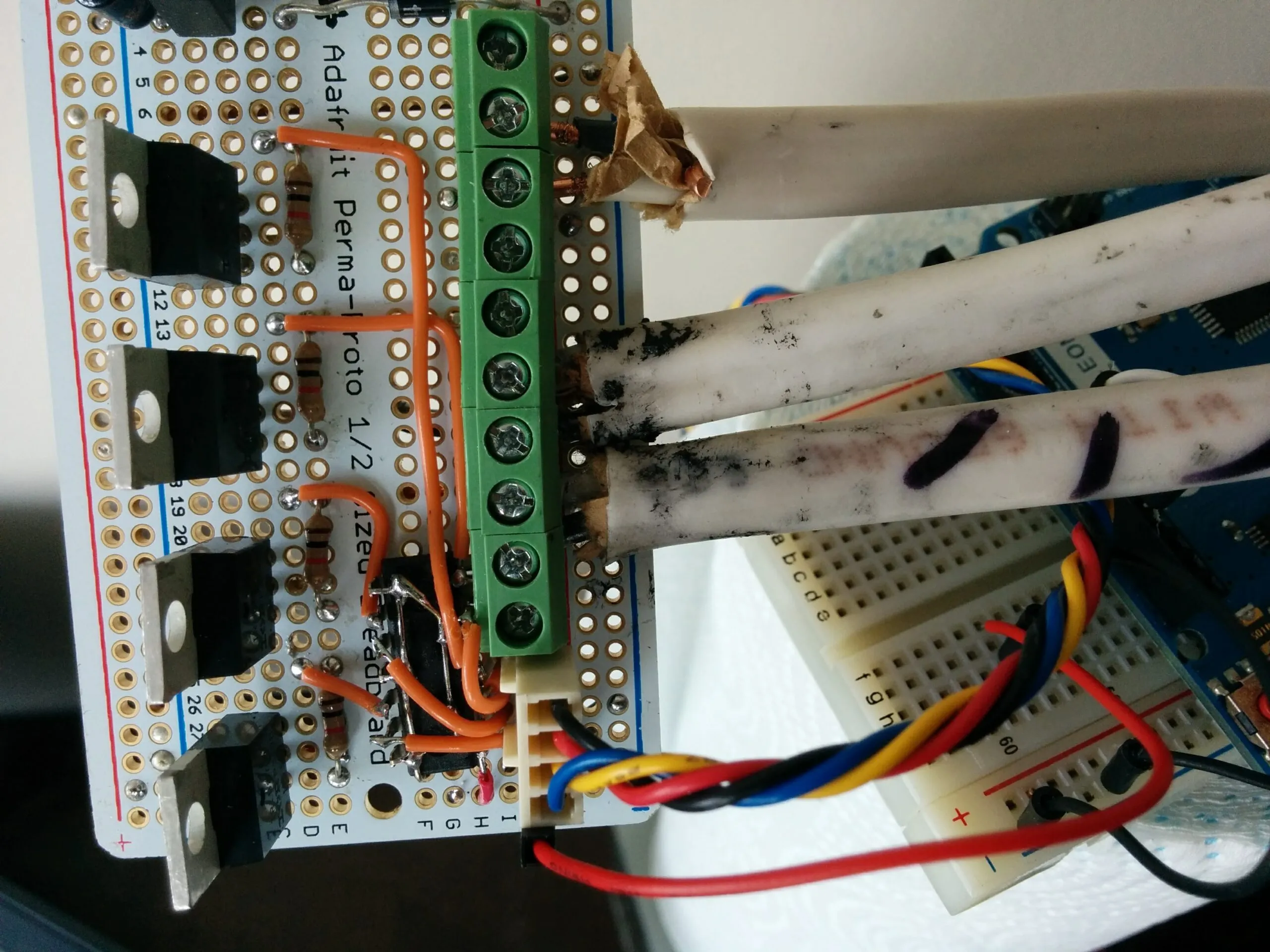 The strip driver: MOSFETs on an Adafruit Perma-Proto, screw terminals fanning out to the ceiling runs.