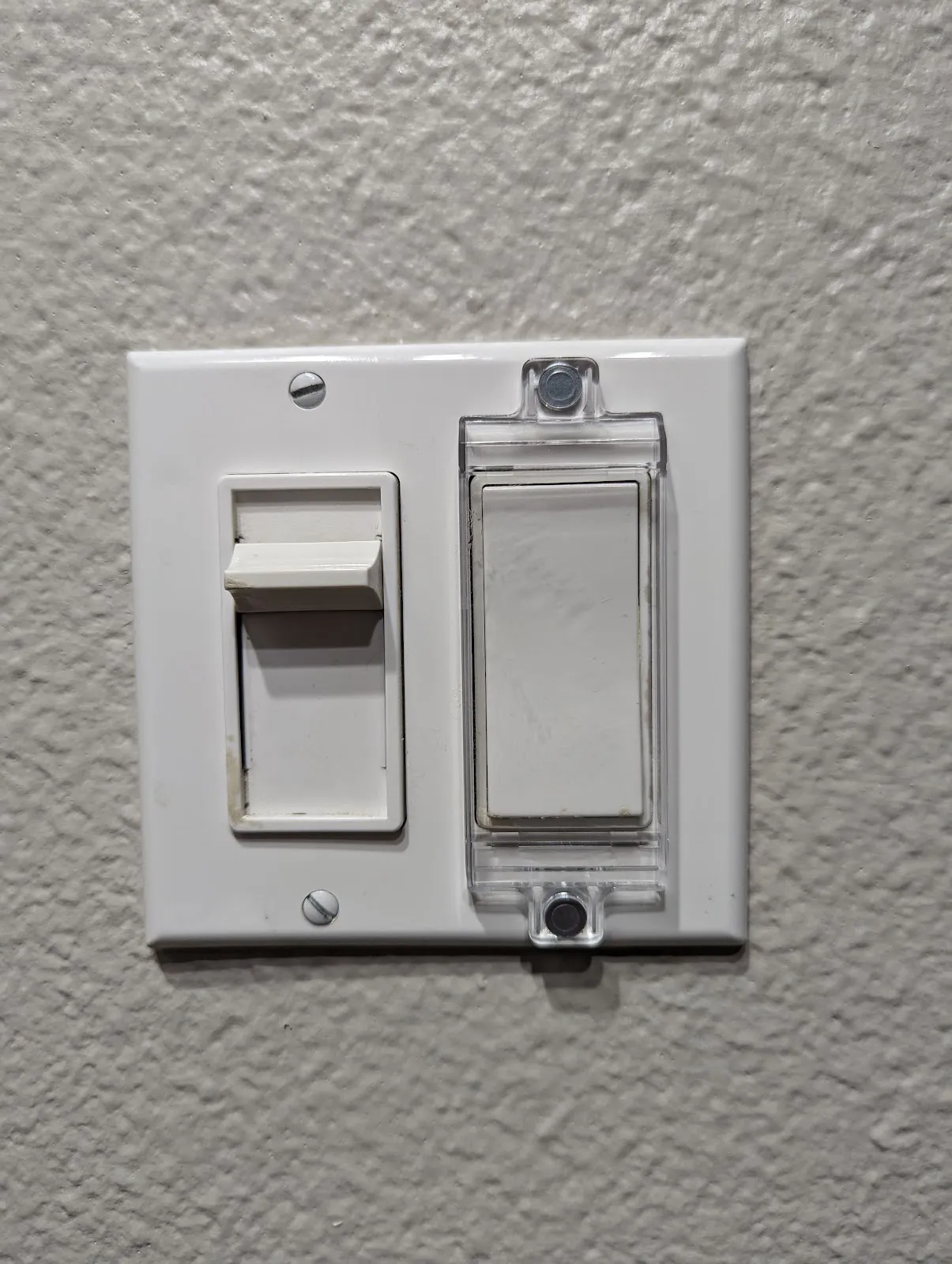 The stubborn slide dimmer beside its covered companion rocker, still without a good smart retrofit.
