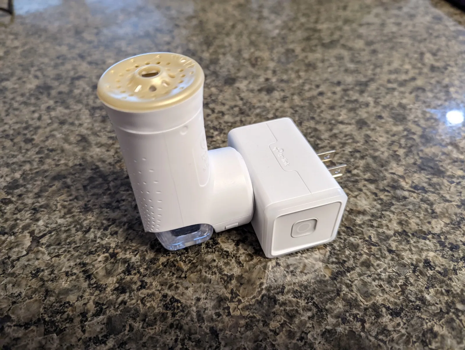 The Glade plug-in air freshener and the Kasa smart plug that switches it.