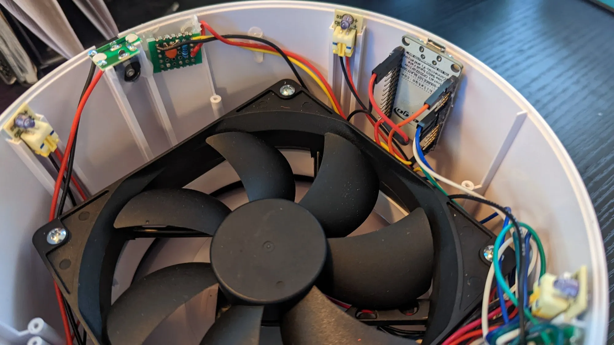 Close on the February 2023 rework: the NodeMCU standing in the shell beside the fan, jumpers routed to the boards on the rim.