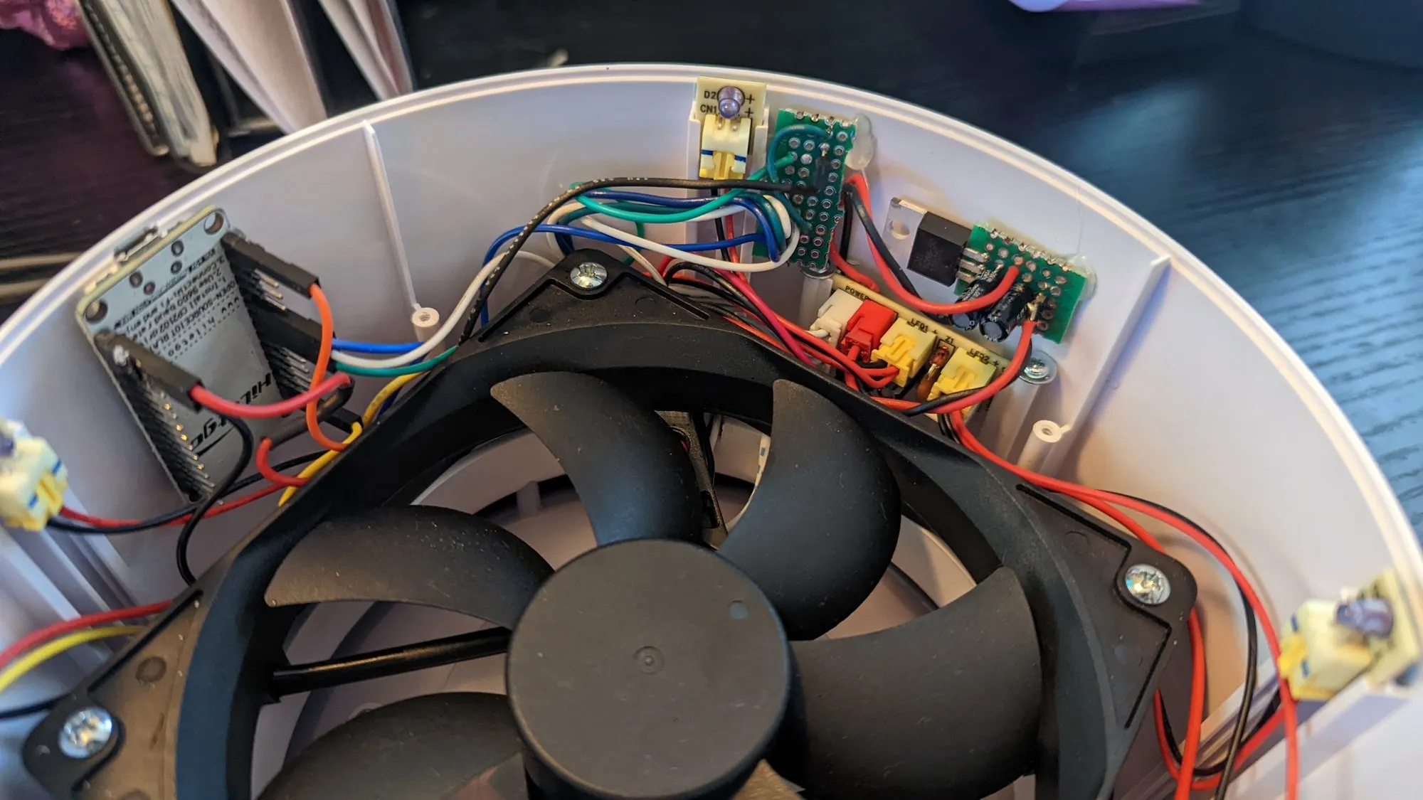 The other side of the February 2023 rework, the regulator and button boards screwed to the shell wall above the fan.
