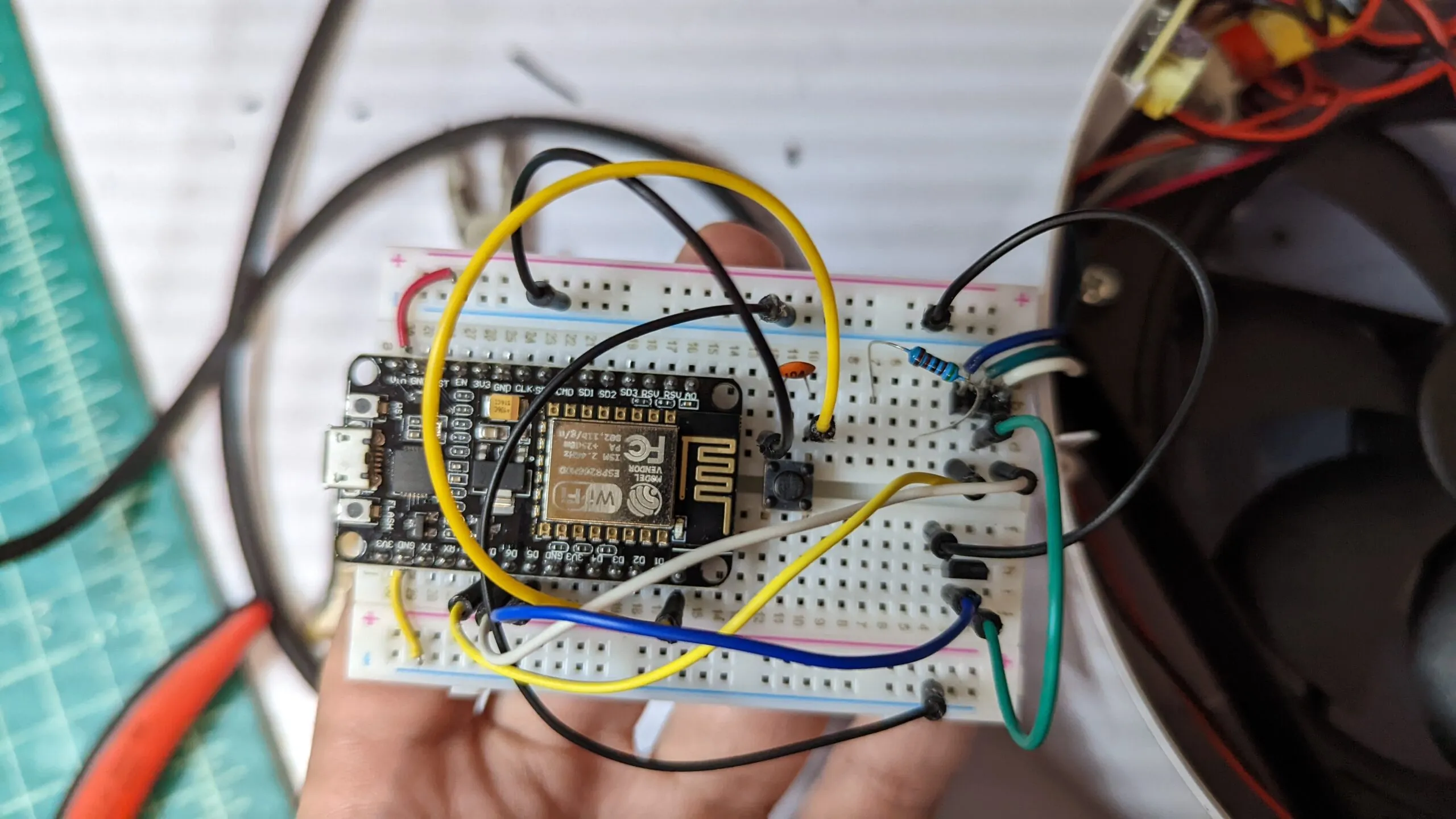 The NodeMCU breadboard in hand, the MOSFET and a resistor beside it, jumper spaghetti fanned out into the filter's harness.