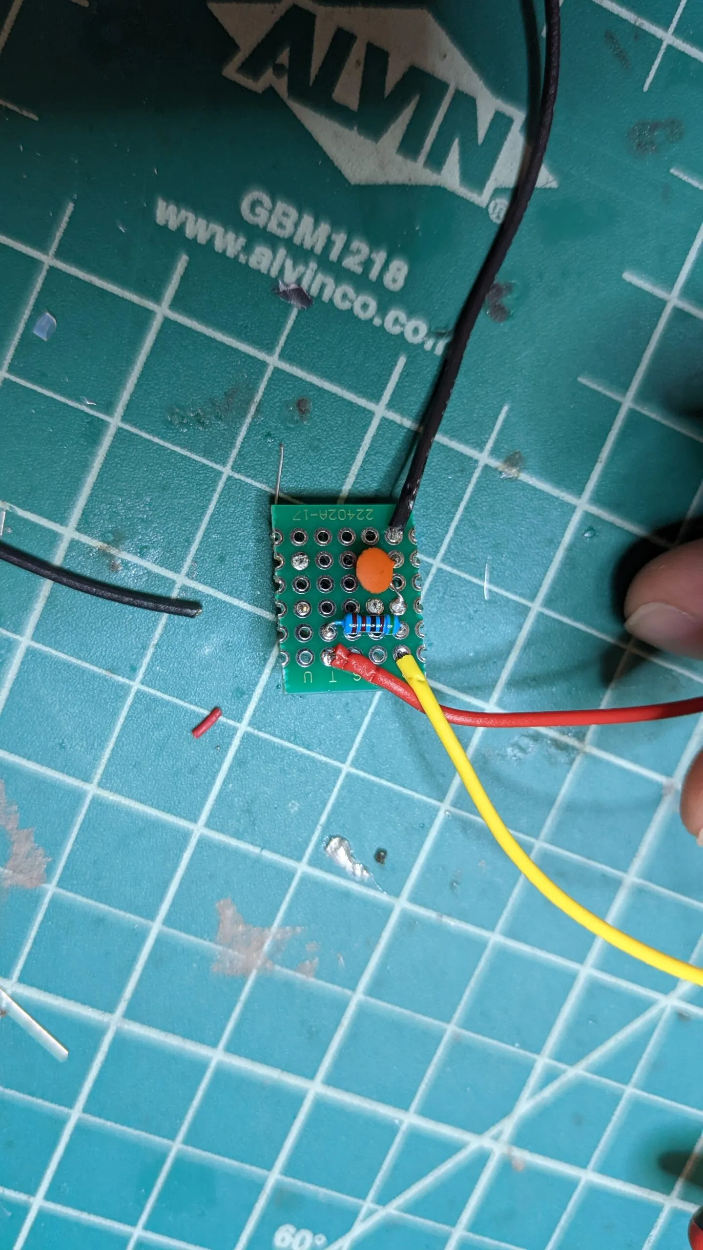 The back of the reset button board: a pull-up resistor and a small ceramic capacitor for debounce, leads soldered out.