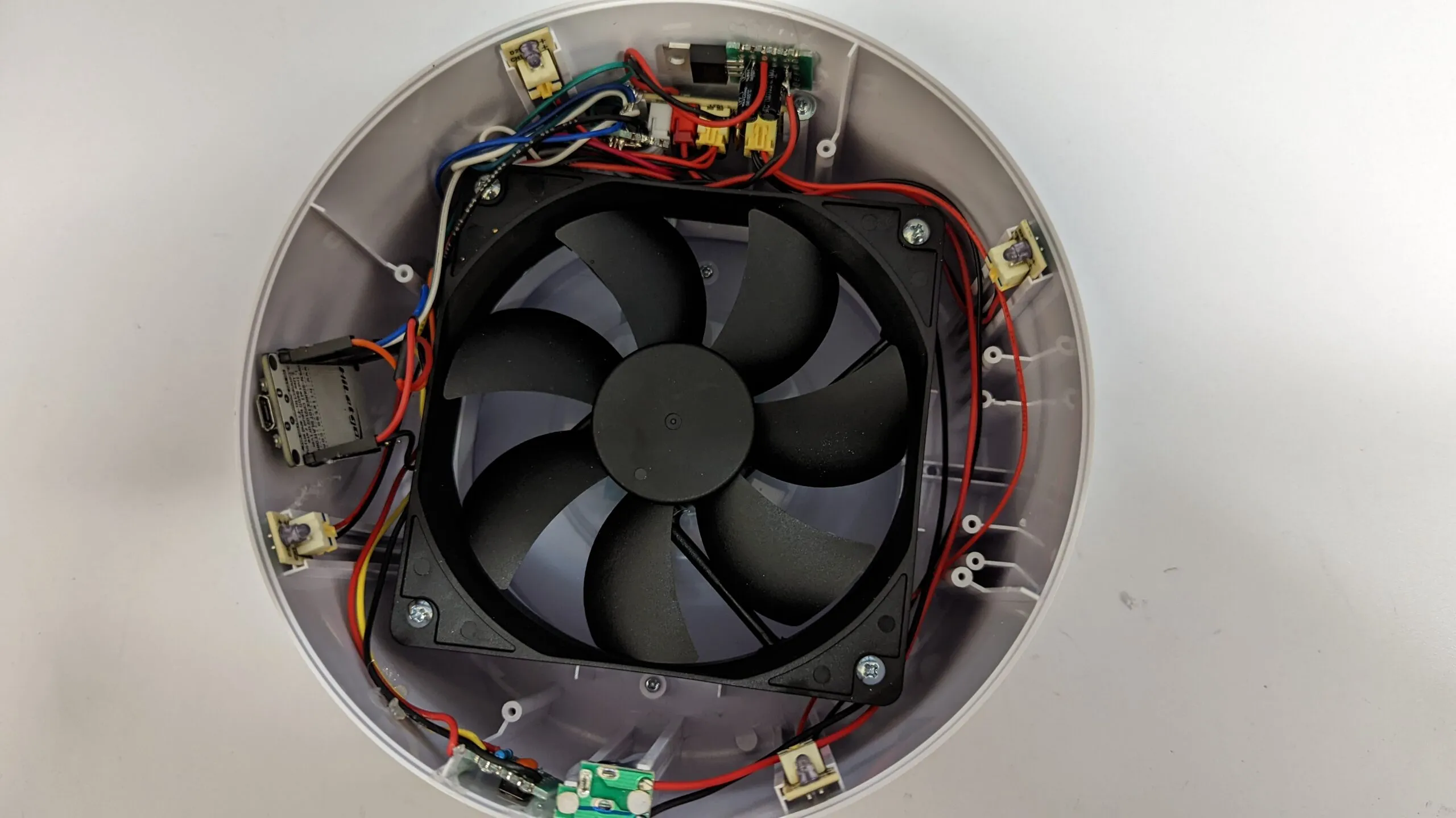The tidied final assembly: fan centered, NodeMCU flat against the shell wall, boards screwed into their bays.