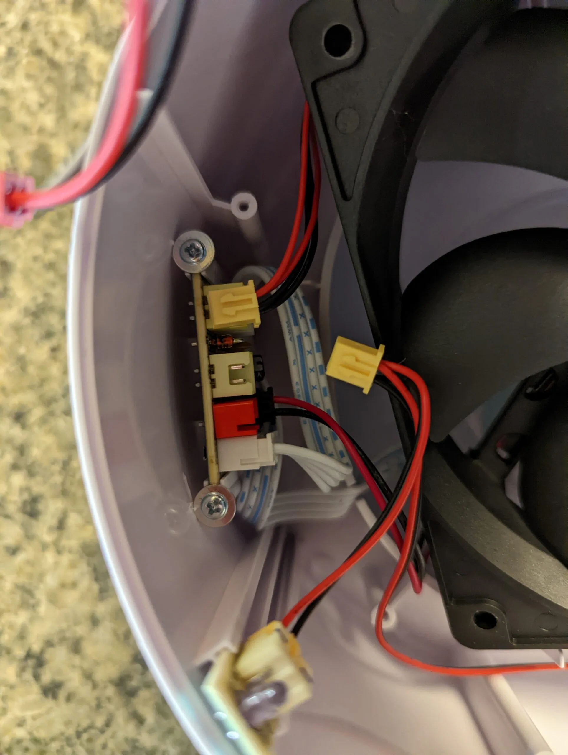 The distribution board screwed to the shell wall, a row of small connectors on it and the fan's yellow plug pulled free.