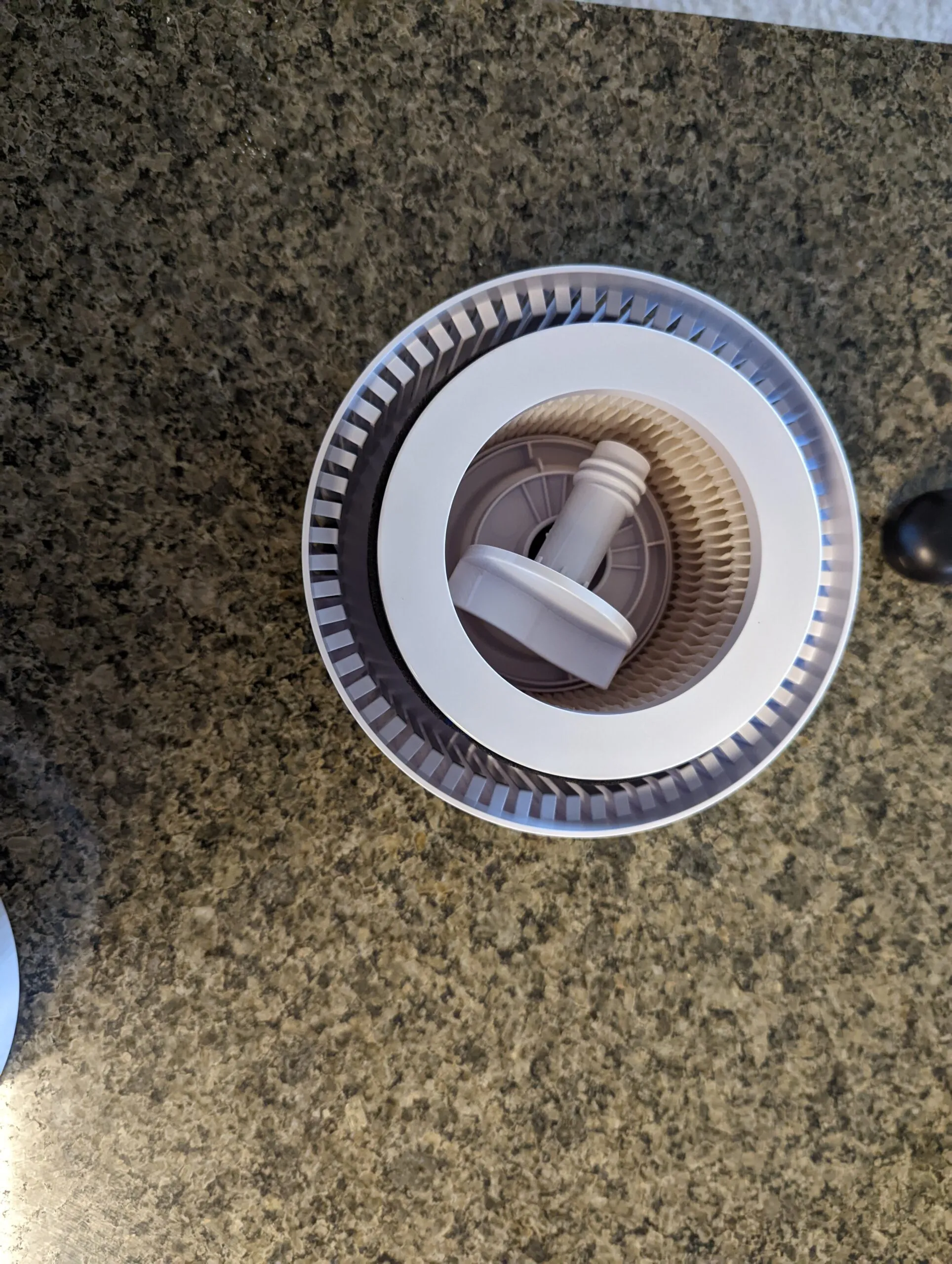 Looking down into the Koios with the lid off: the HEPA cartridge sitting in the base, the gray plastic screw knob on top holding it in.