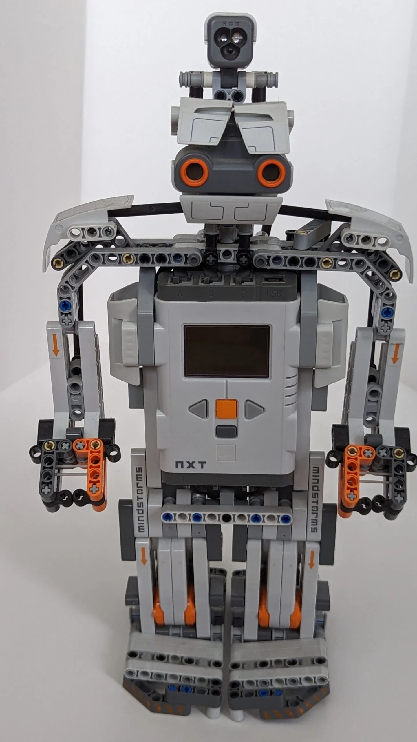 Beta Rex face on: ultrasonic eyes above the NXT-brick chest, wing-blade shoulders.