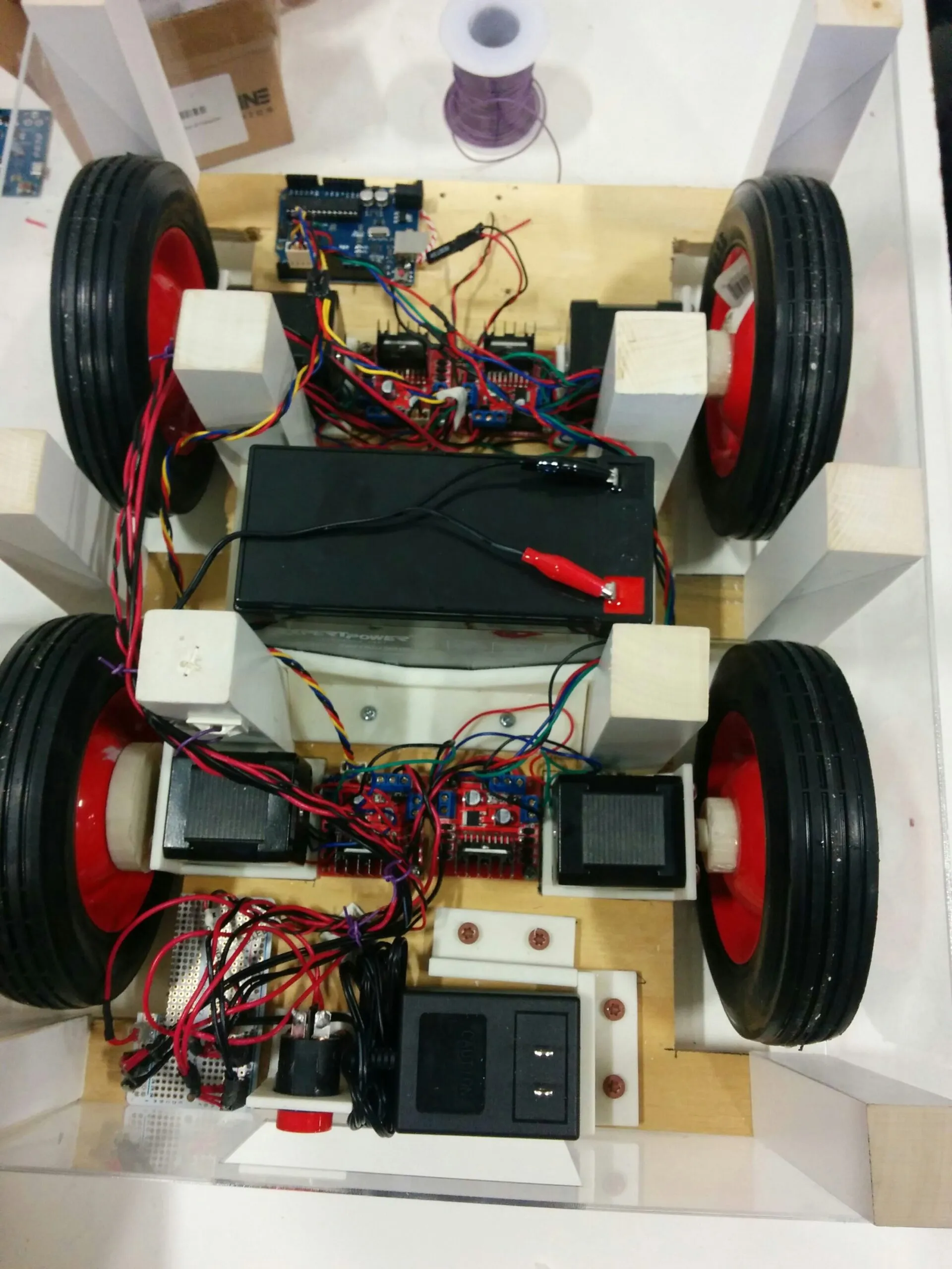 Orion wired end to end: Arduino up front, an L298N and stepper at each corner, SLA battery amidships, charger and e-stop at the tail.