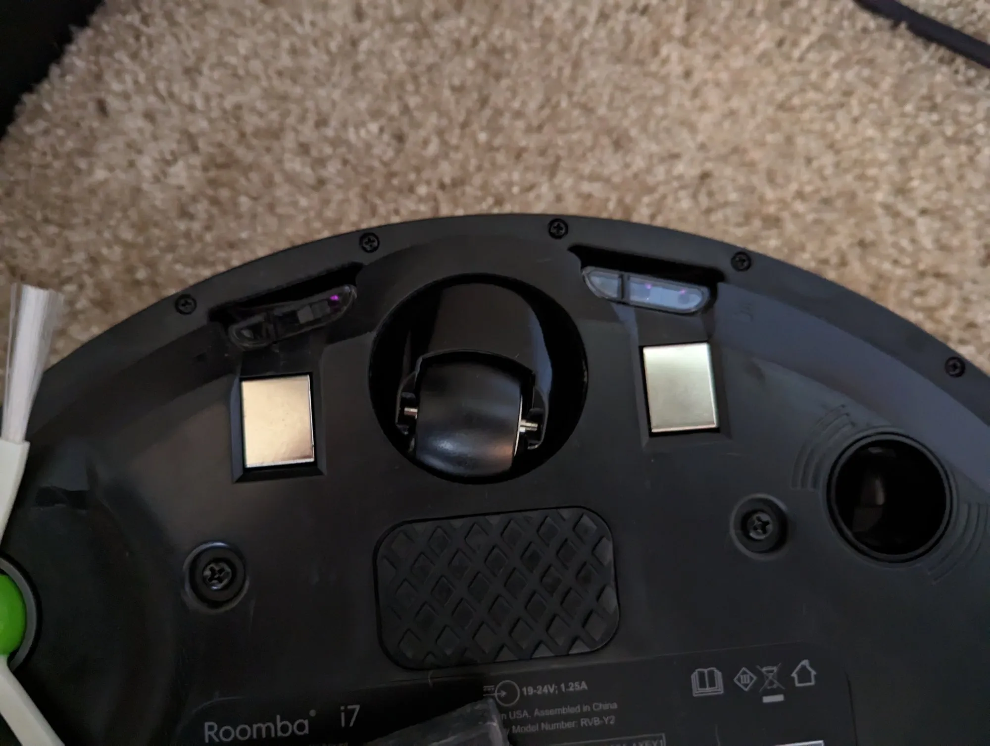 The underside of the Roomba i7, wheels and charging contacts, with the Roomba i7 label.