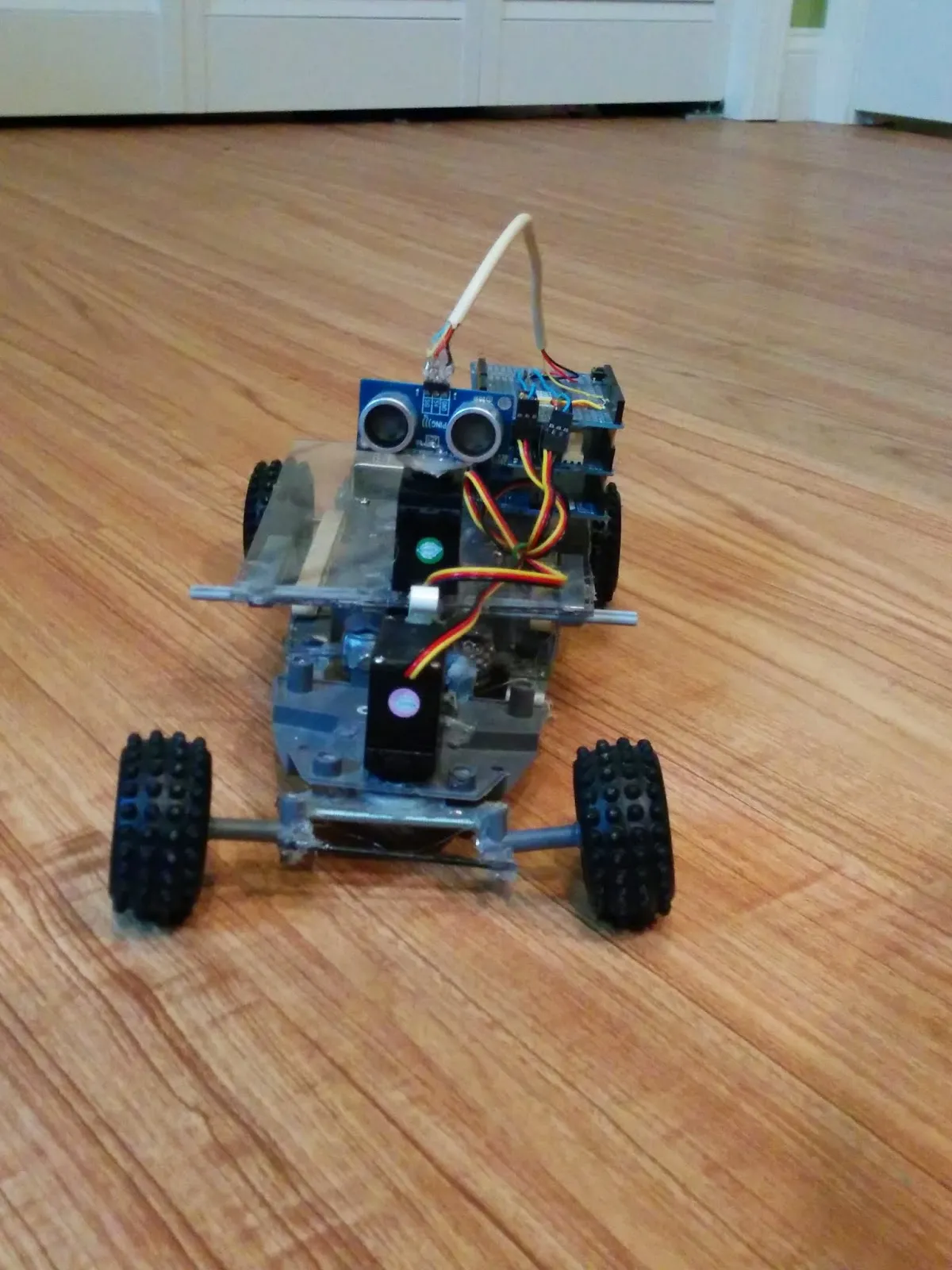 RoverBot in 2014, ultrasonic sensor staring down the camera from the clear polycarbonate deck.