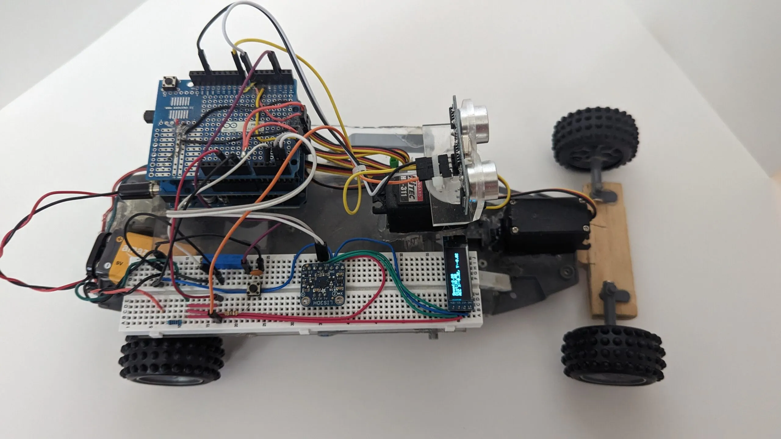 RoverBot from above: protoshield stack, breadboard, OLED readout, and the head servo with its ultrasonic mast.