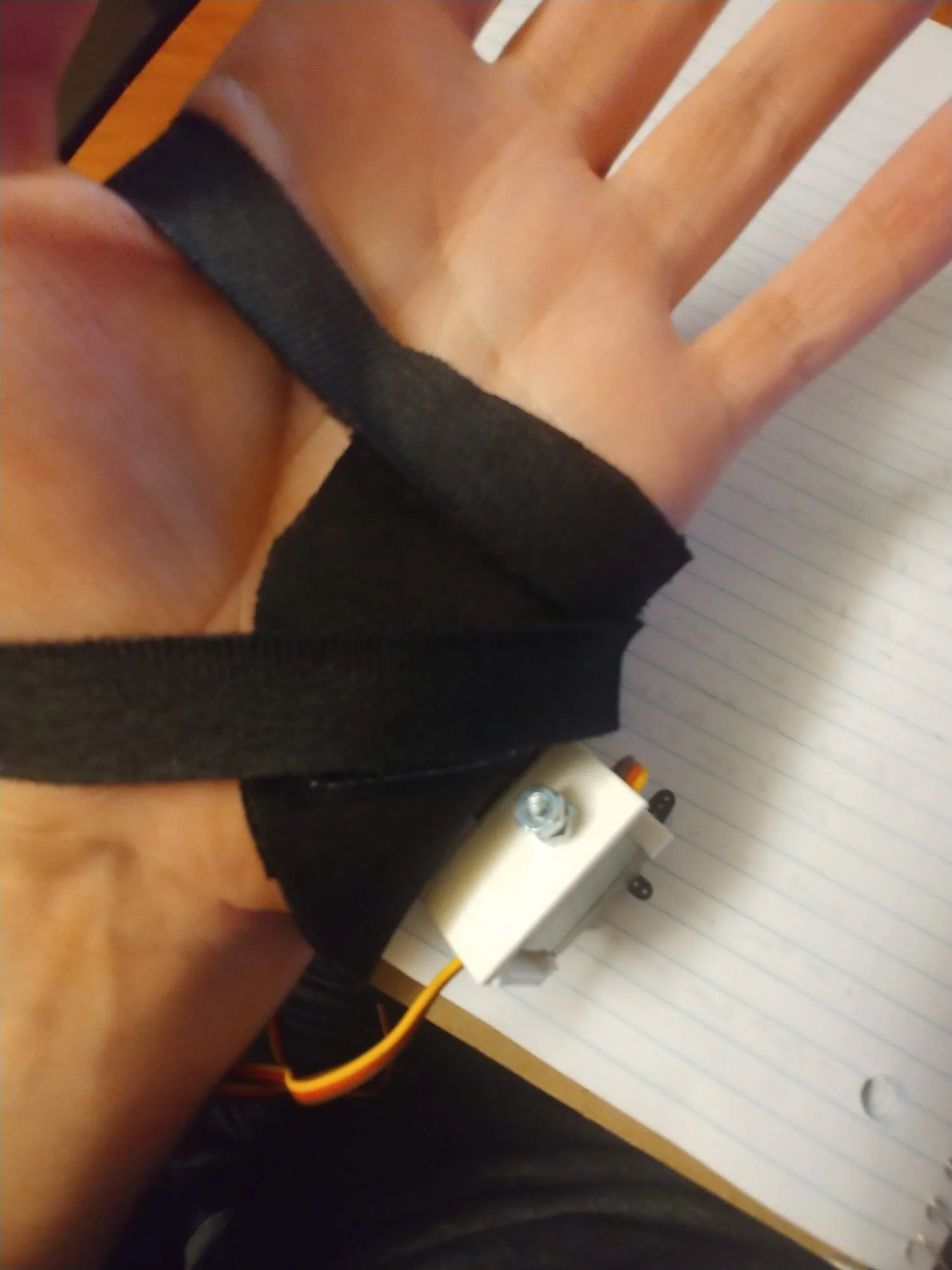 The bare neoprene brace wrapped around the palm with a small servo at the wrist and no finger on it yet.