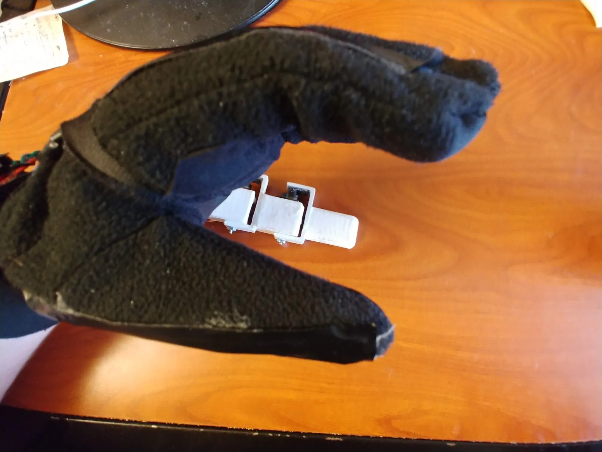 The worn sensing glove on the desk, a sensor pad lifting away from the fabric.