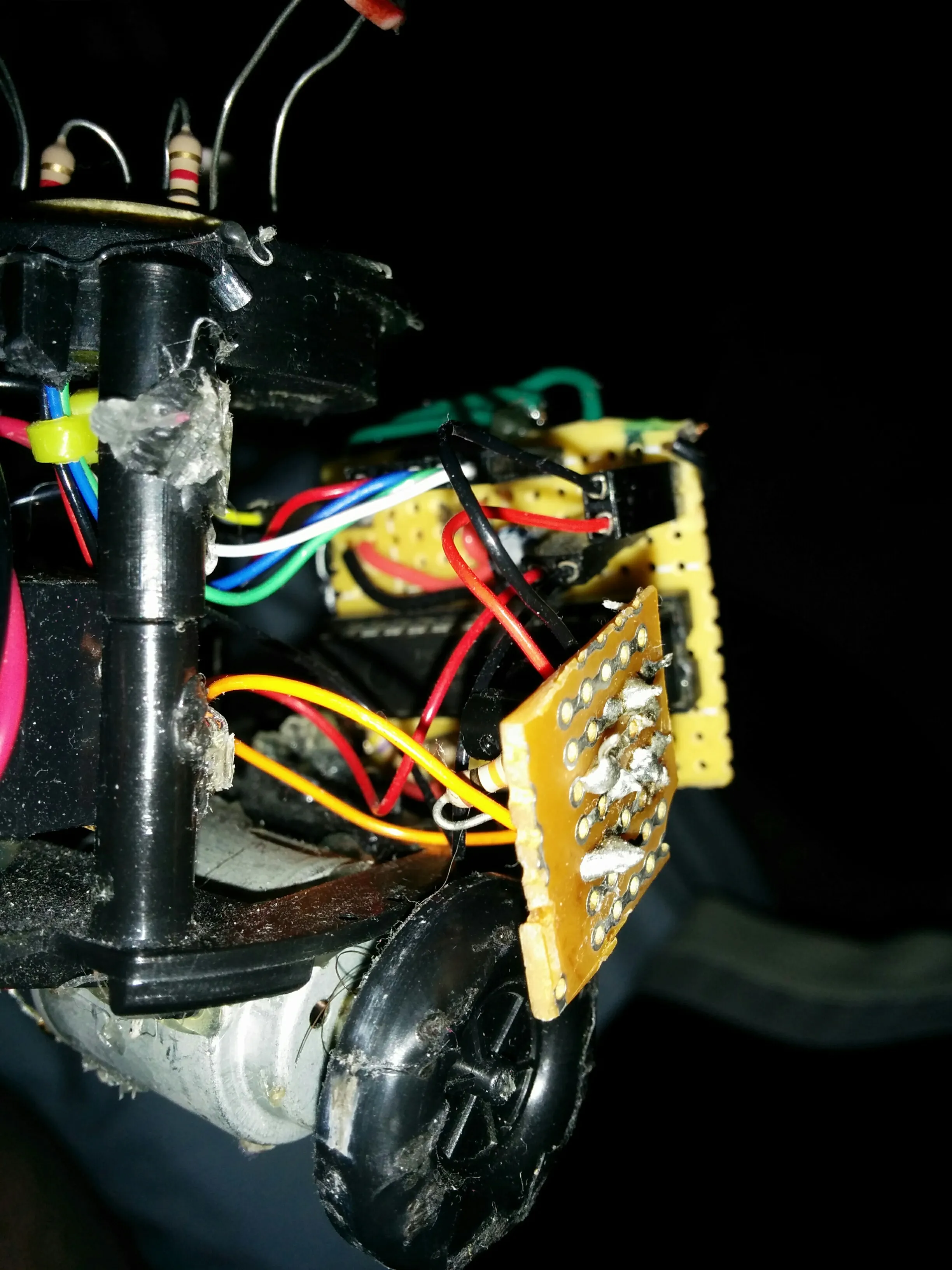 Side detail of Triclops: drive motor, wheel, and perfboards hanging off the frame.
