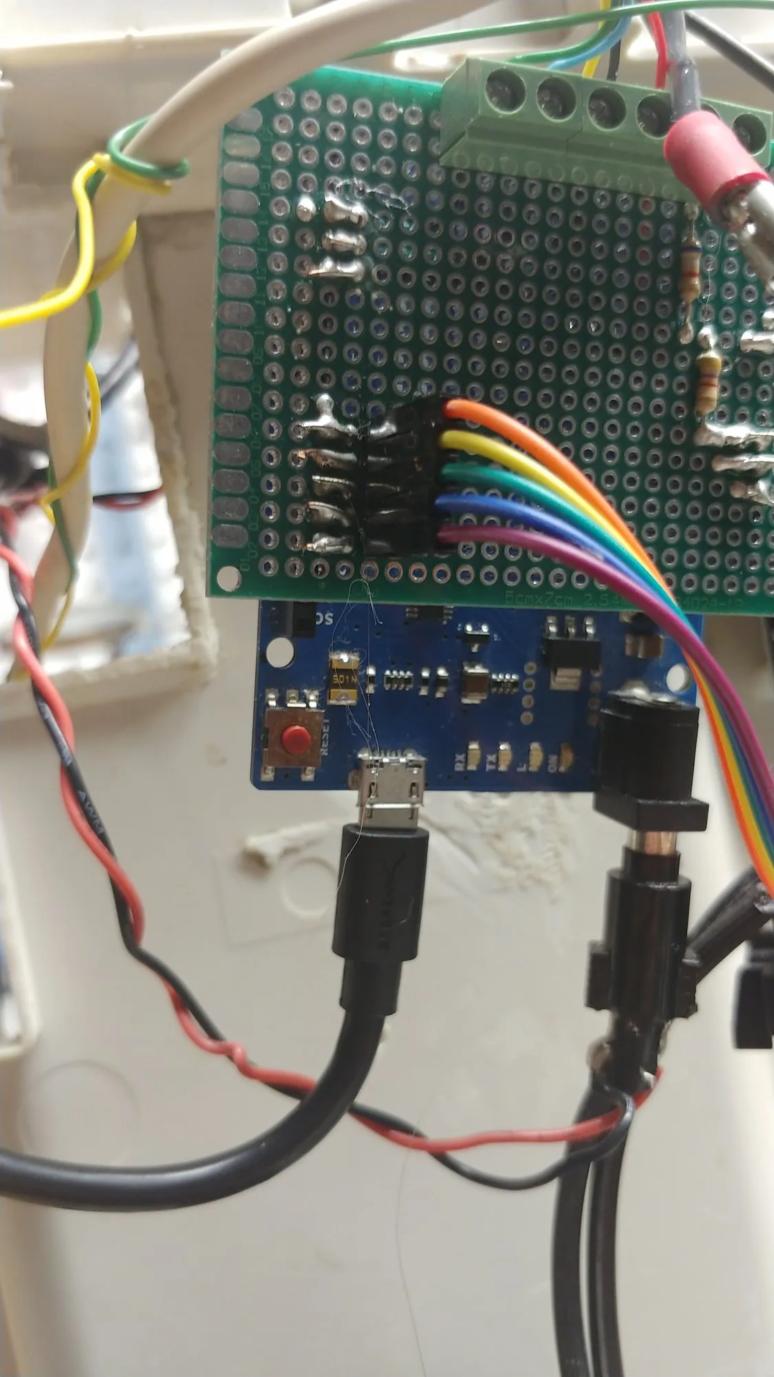 Close on the Leonardo interface board: screw terminals, the ribbon header, and the Leonardo's reset button and status lights below.